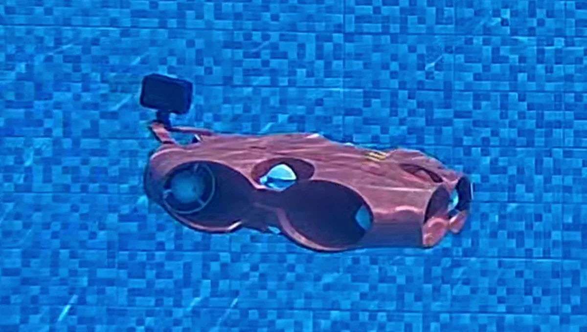 The first-generation Abyss inspection vehicle underwater: a red hull body with ducted thrusters and a mounted camera.